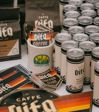 12oz bags of Theo blend, Vita Cold Brew cans, and various Caffe Vita branded merch