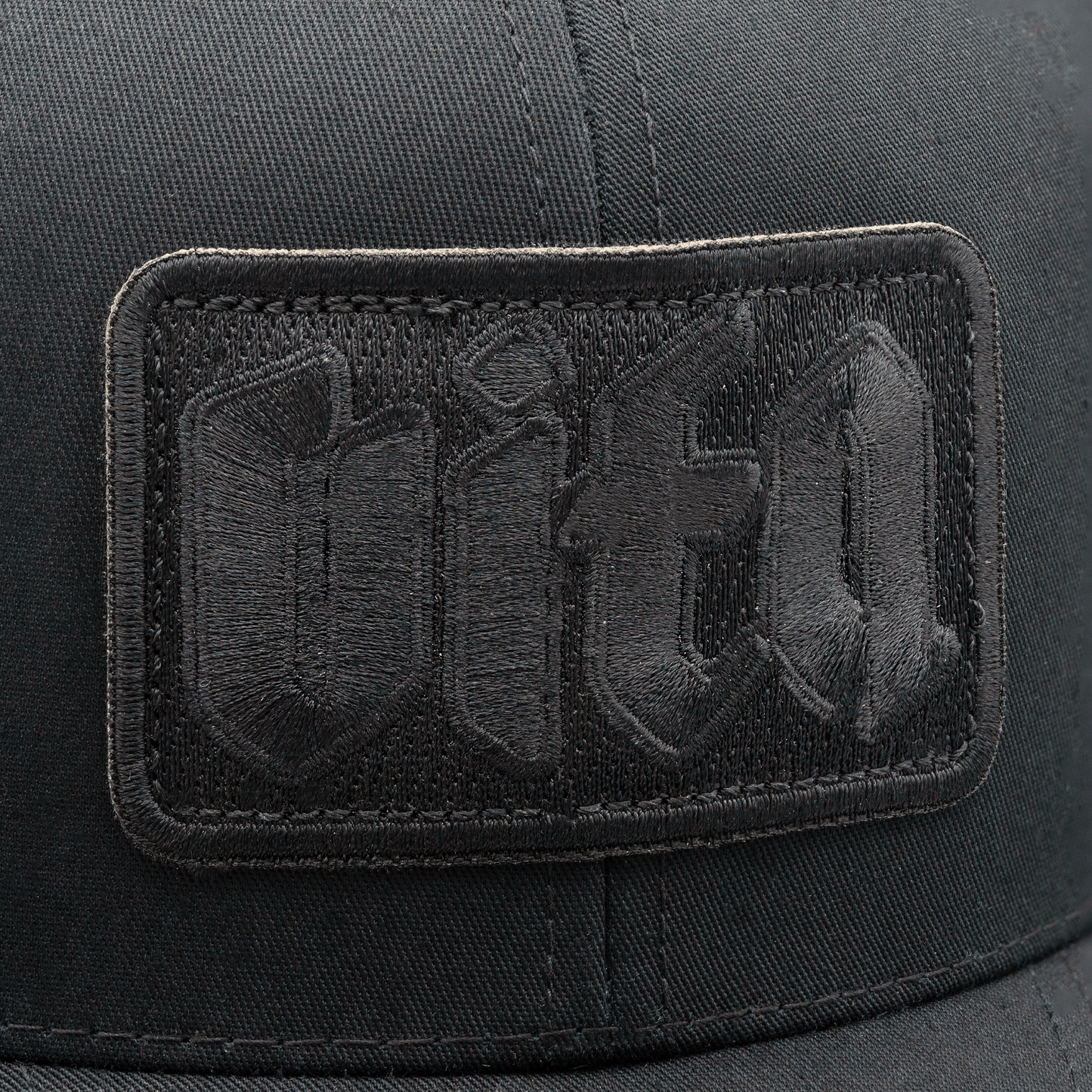 Close up detail of black Vita patch on front of Shadow Trucker.