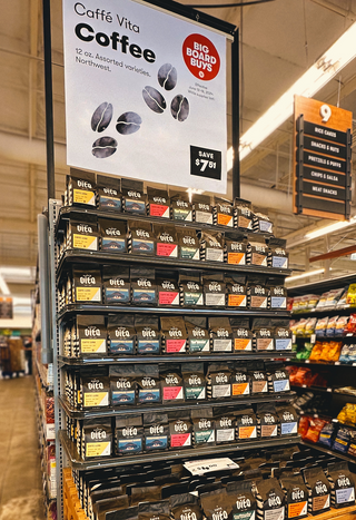 Display of 12oz bags of various Vita coffees in grocery store