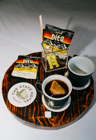 Caffe Luna singles on tray with The State Hotel mugs and coasters