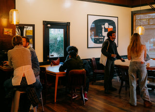Caffe Vita's Queen Anne cafe featuring various customers at tables and a Pearl Jam print.