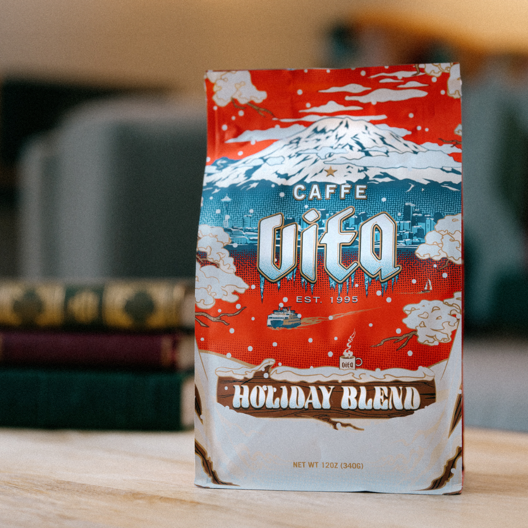 Image: 12oz Holiday Blend bag in front of couch and books.