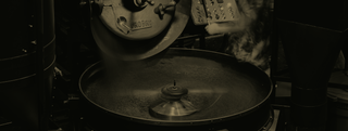 Black and white image of Probat roaster in the process of roasting beans.