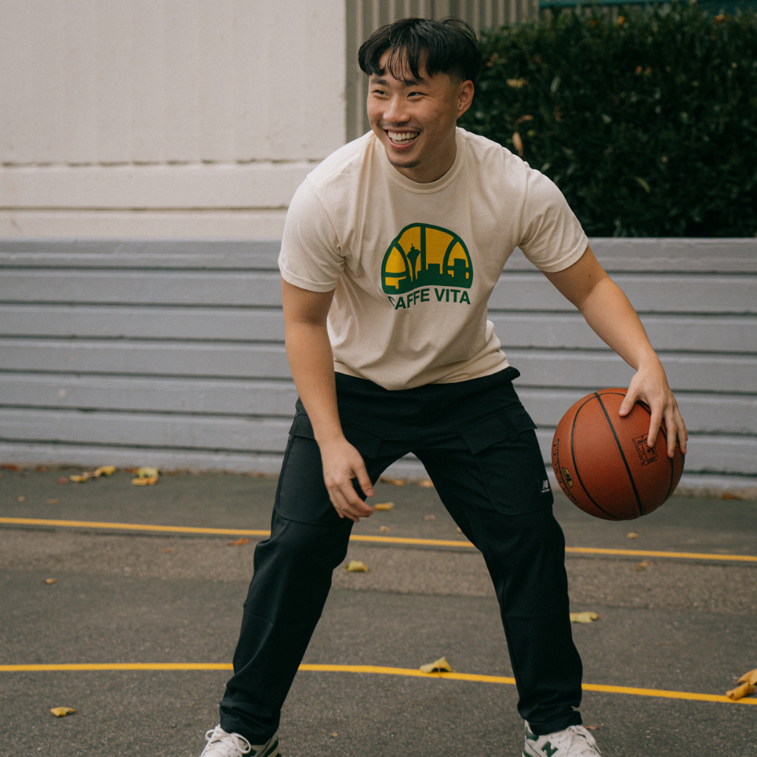 Image: model wearing sonics tee playing basketball.