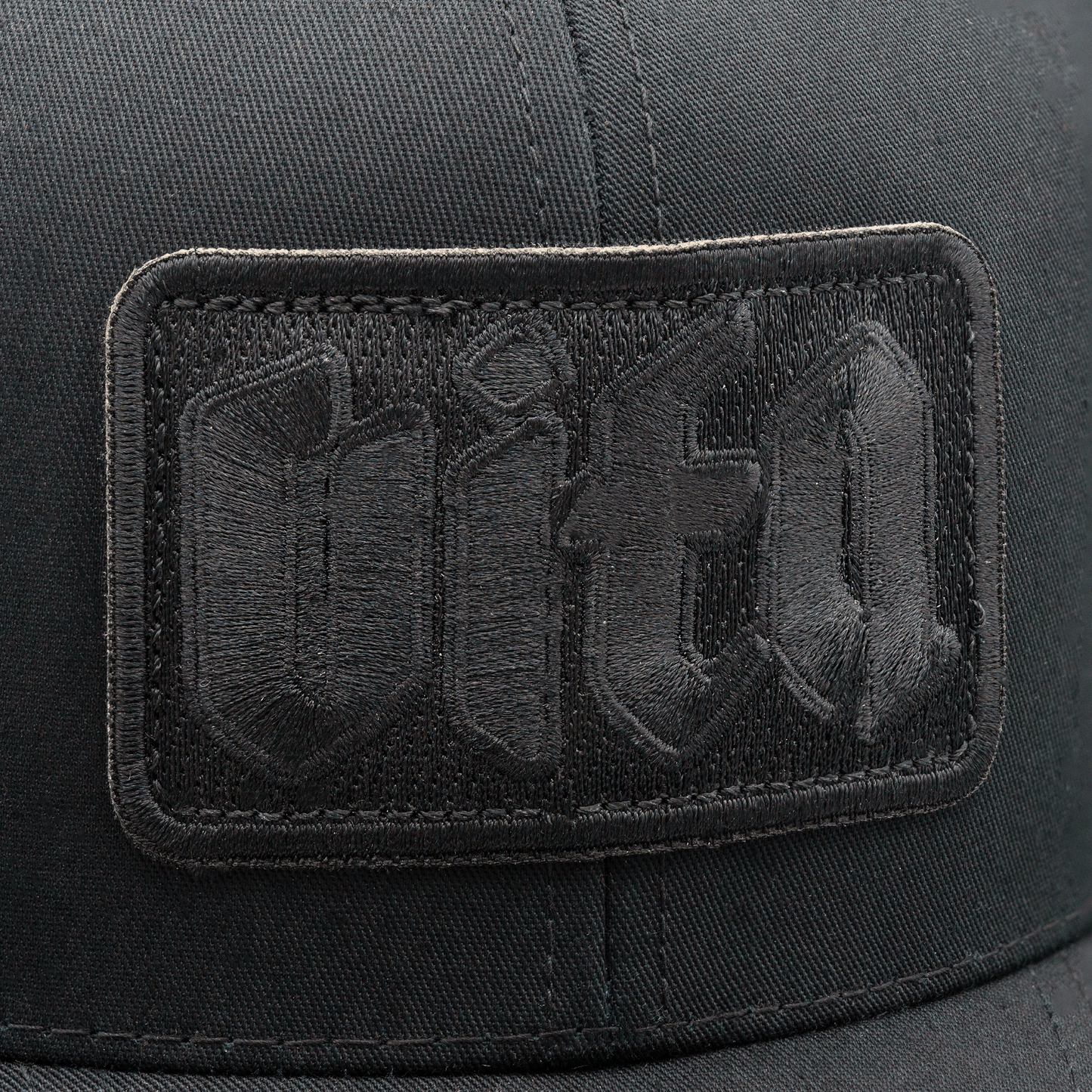 Close up detail of black Vita patch on front of Shadow Trucker.