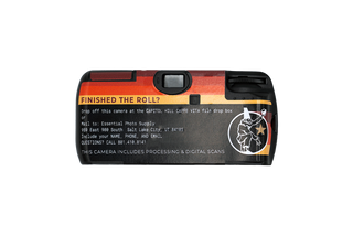 Black disposable camera, back, with sunset stripes across top, pulcinella in white, and drop off instructions