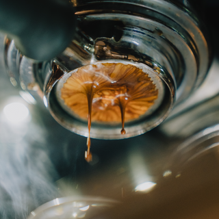 Close up of an espresso machine pulling a shot.
